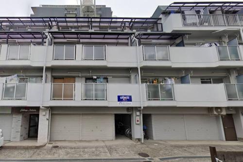 an apartment building with two garages in front of it at 2 min from Nakatsu Station 5person apartment in Osaka