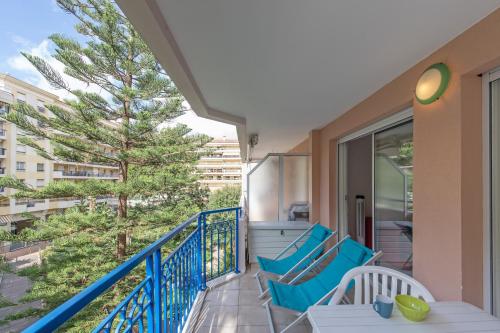 un balcon avec des chaises bleues et un arbre dans l'établissement 