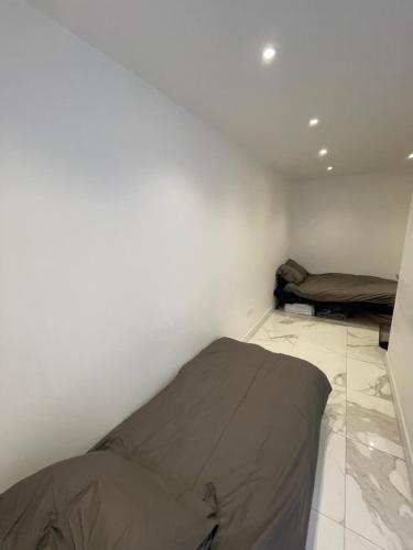 Cette chambre blanche comprend un lit et un matelas. dans l'établissement Appartement au rez de chaussée pres de gare de lyon, à Paris