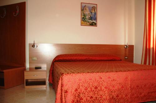 a bedroom with a bed with a red bedspread at Villa Verde 2 in Guidonia