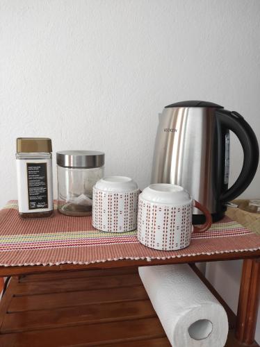 a shelf with a coffee pot and cups on it at Casa da Cabana in Budens
