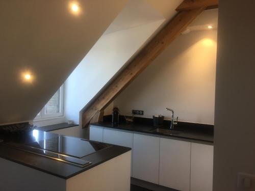 une cuisine avec des comptoirs noirs et un escalier dans l'établissement Annecy centre - 3 chambres - 90m2 5 min du lac, à Annecy