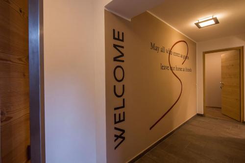 a hallway with a wall with a sign that reads newelazar at Chalet S Apartments in Campo Tures
