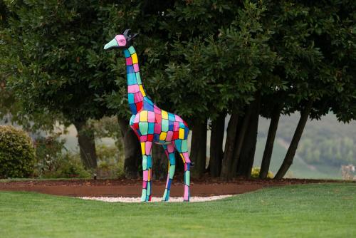 a colorful statue of a giraffe in the grass at Cascina Portinale 8 in Alba