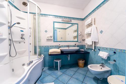 a blue and white bathroom with a tub and sink at Romantica Room & SPA in Ischia