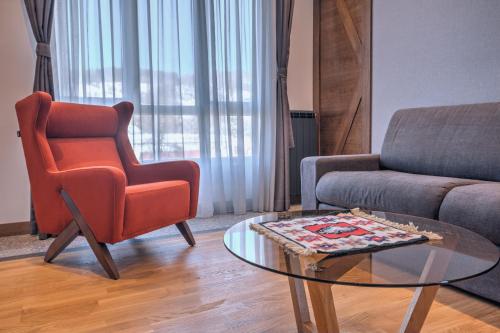 a living room with a chair and a coffee table at MODERN MOUNTAIN II in Kolašin