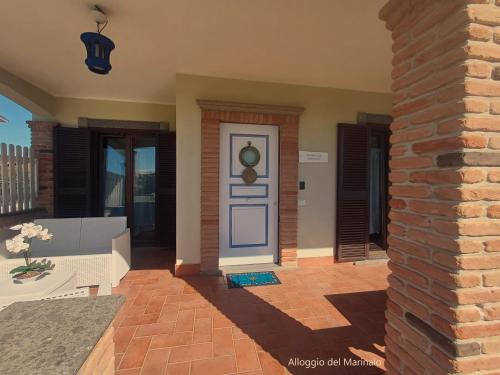 a house with a blue door and a brick pillar at Alloggi Turistici con Piscina Palestra Jacuzzi Sauna - All Inclusive in Anzio