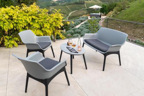 three chairs and a table on a patio at Cascina Portinale 8 in Alba
