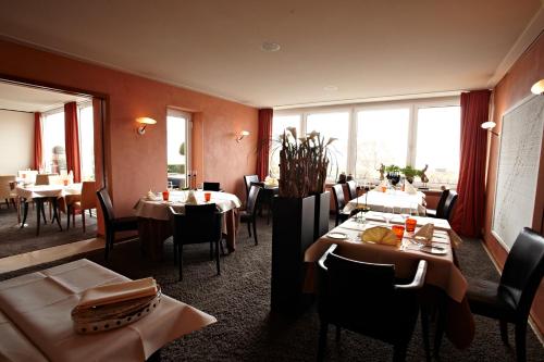 a dining room with tables and chairs and windows at Romantik Hotel Residenz am See in Meersburg