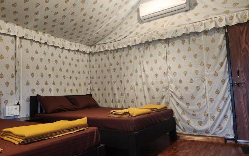 a room with two beds and a wall with curtains at Woods Creek in Dandeli