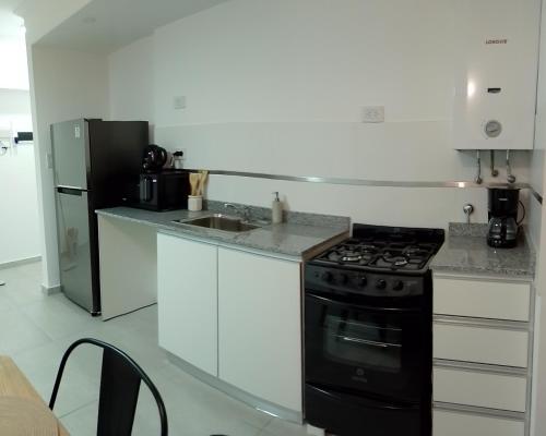 a kitchen with a black stove and a refrigerator at Departamento céntrico zona clínicas MIT - Nefrología in Santa Fe