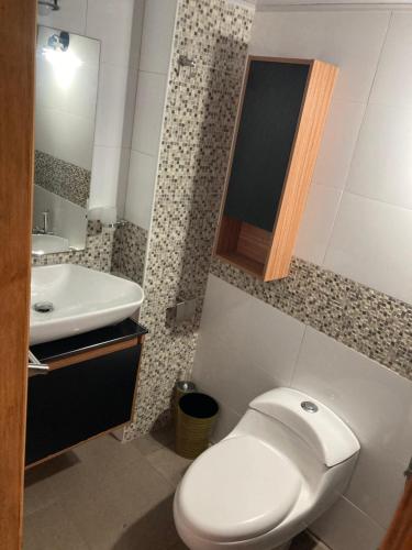 a bathroom with a white toilet and a sink at Apartamento vista al mar in Porlamar