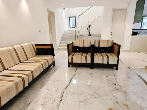 a living room with two couches on a marble floor at Mizzle Exotica Lonavala in Lonavala