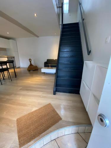 un couloir avec un escalier, un canapé et un tapis dans l'établissement Petite maison de ville, à Lisses