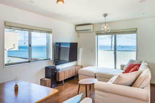 a living room with a couch and a table at Oceanfront Villa Hale Kahakai プライベートサウナ in Kōembō