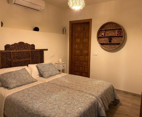 a bedroom with a bed and a mirror on the wall at CASA PARVATHI CANDELEDA in Candeleda