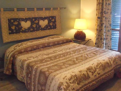 a bedroom with a bed with a blanket and a lamp at La Casetta Del Dahu in Limone Piemonte