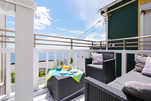 a balcony with two chairs and a table on a balcony at Oceanfront Villa Hale Kahakai プライベートサウナ in Kōembō