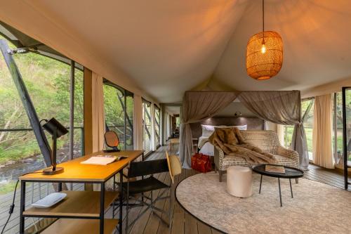 a room with a bed and a desk and a table at Mbizane Escarpment Retreat in Schoemanskloof