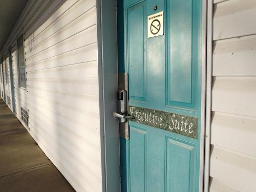a blue door with a no smoking sign on it at The Ritz Cafe and Motor Inn in Whitecourt