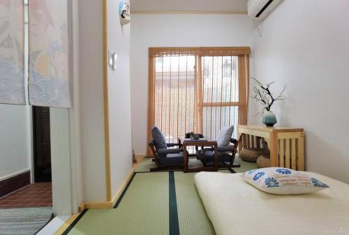 a room with two beds and a table and chairs at House[80㎡]/Direct to Numba 7 min ~楽雅苑 Rakugaen~ in Osaka