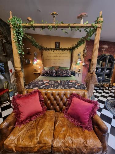 a large bed with a leather couch in a room at Le terrier aux merveilles in Pont-d'Ouilly