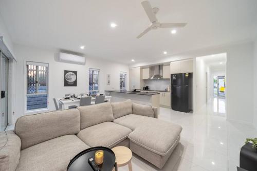 a living room with a couch and a kitchen at Belleview Home - Brand New 4 Bedroom House near Ipswich in Ripley