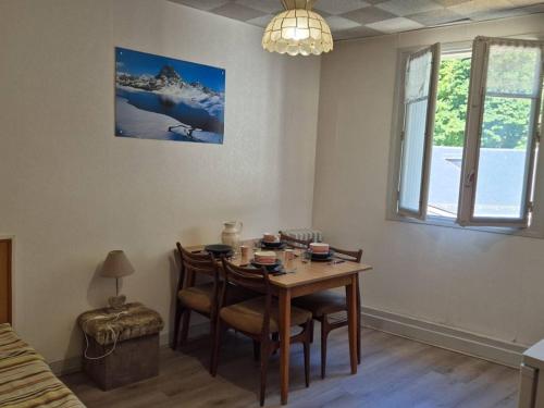 une table de salle à manger et des chaises dans une pièce dans l'établissement Appartement cosy 4 pers à 50m des thermes et 300m des pistes, wifi, ascenseur - FR-1-234-128, à Cauterets