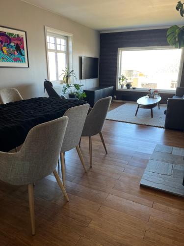 a living room with a dining room table and chairs at Villa apartment in Trondheim