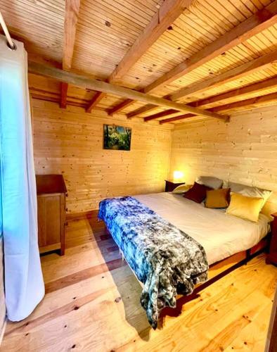 a bedroom with a bed in a wooden cabin at Domaine de Faye in Sauvigny-les-Bois