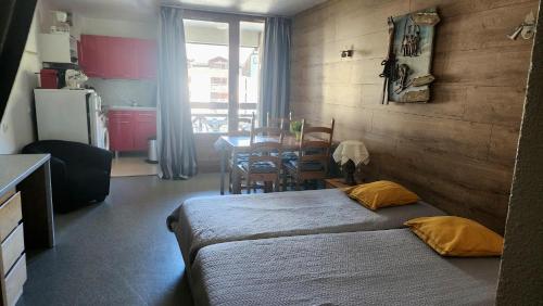 une chambre avec deux lits, une table et une cuisine dans l'établissement Vanessa, à Brides-les-Bains