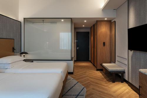 a hotel room with two beds and a tv at Sheraton Mall of the Emirates Hotel, Dubai in Dubai