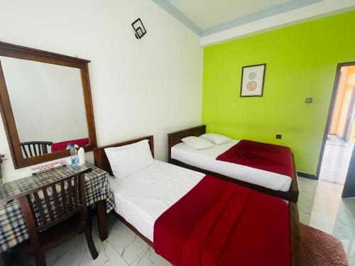 two beds in a room with green and white at 240 - Two forty in Bandarawela