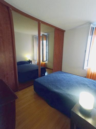 une chambre d'hôtel avec un lit et un miroir dans l'établissement Family apartment near Paris, à Alfortville