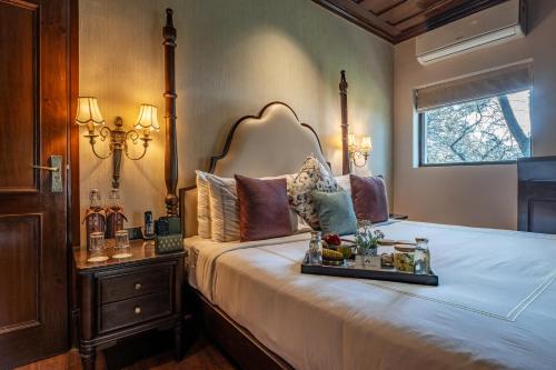 a bedroom with a bed with a tray of food on it at Brij Anayra Dharamshala - A Himalayan Luxury Retreat in Dharamshala