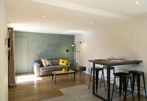 un salon avec une table et un canapé dans l'établissement Le Presbytère de Thiverval, à Thiverval-Grignon