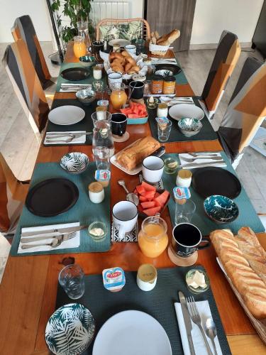 a long table with plates and food on it at l'Eden caché in Beaune-la-Rolande
