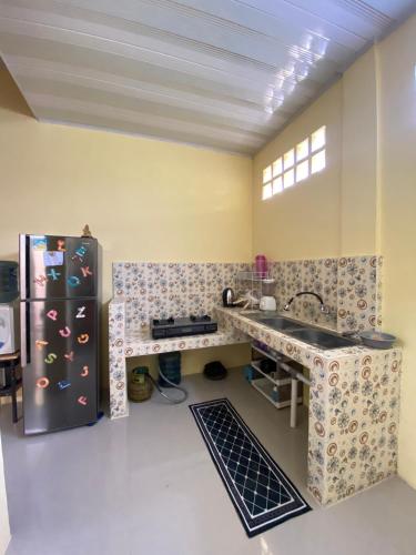 a kitchen with a sink and a refrigerator at Ben And Ethan Homestay in Balige