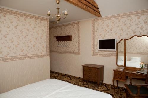 - une chambre avec un lit, un miroir et une commode dans l'établissement Ööbikuoru Villa, à Rõuge