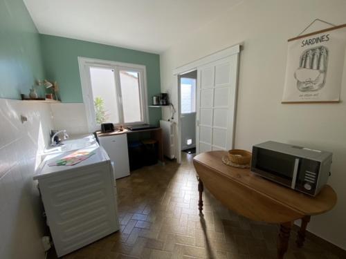 une cuisine avec une table et un four micro-ondes. dans l'établissement Le beau séjour, à Grosbreuil