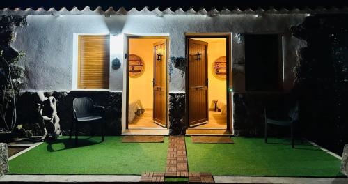 a front door of a house with a green lawn at CASA PARVATHI CANDELEDA in Candeleda