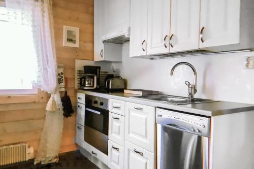 a kitchen with white cabinets and a sink at Villa in Kalajoki