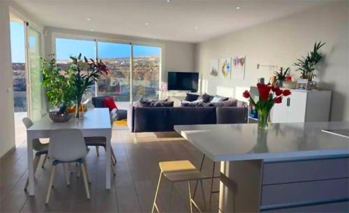 a kitchen and living room with a table and a couch at Paraiso House in Callao Salvaje