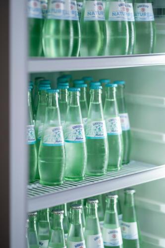 a refrigerator filled with lots of bottles of milk at Mühlenkamp Hotel & Gastronomie in Oelde