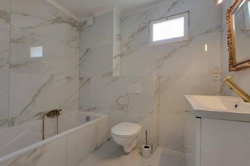 une salle de bain blanche avec des toilettes et un lavabo dans l'établissement Apartment 3 pieces par la mer avec climatisation, à Nice