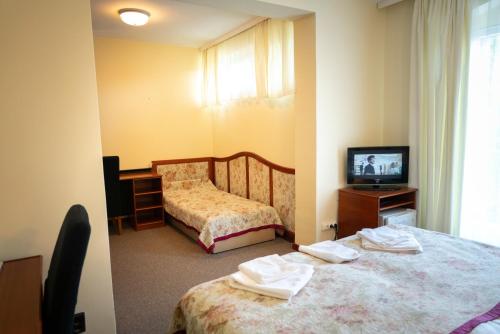 a hotel room with two beds and a television at Hotel Bobbio in Budapest