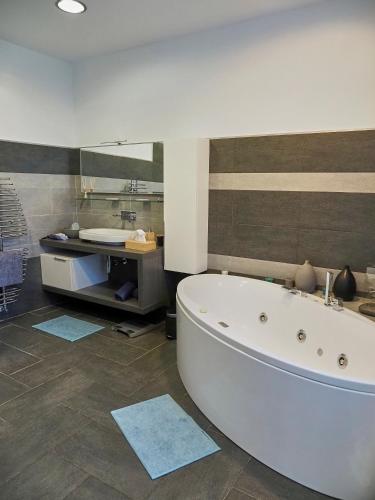 a bathroom with a large white tub and a sink at La Canonica di Soglio in Camerano Casasco