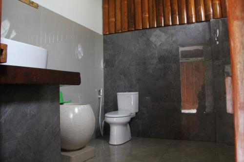 a bathroom with a toilet and a shower at Sam's Bungalows And Treks in Bukit Lawang