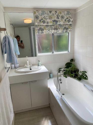 a bathroom with a sink and a bath tub and a mirror at Moonshine in Hermanus