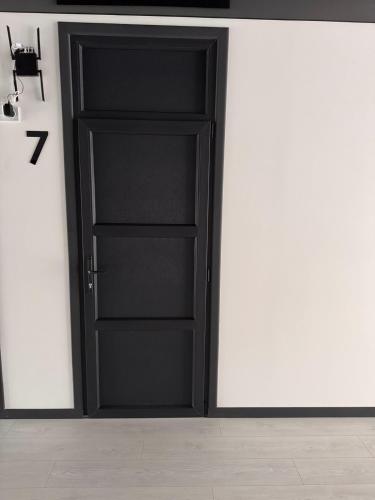 an open black door in a white room at Готель WeLKoMe in Krivorovnya